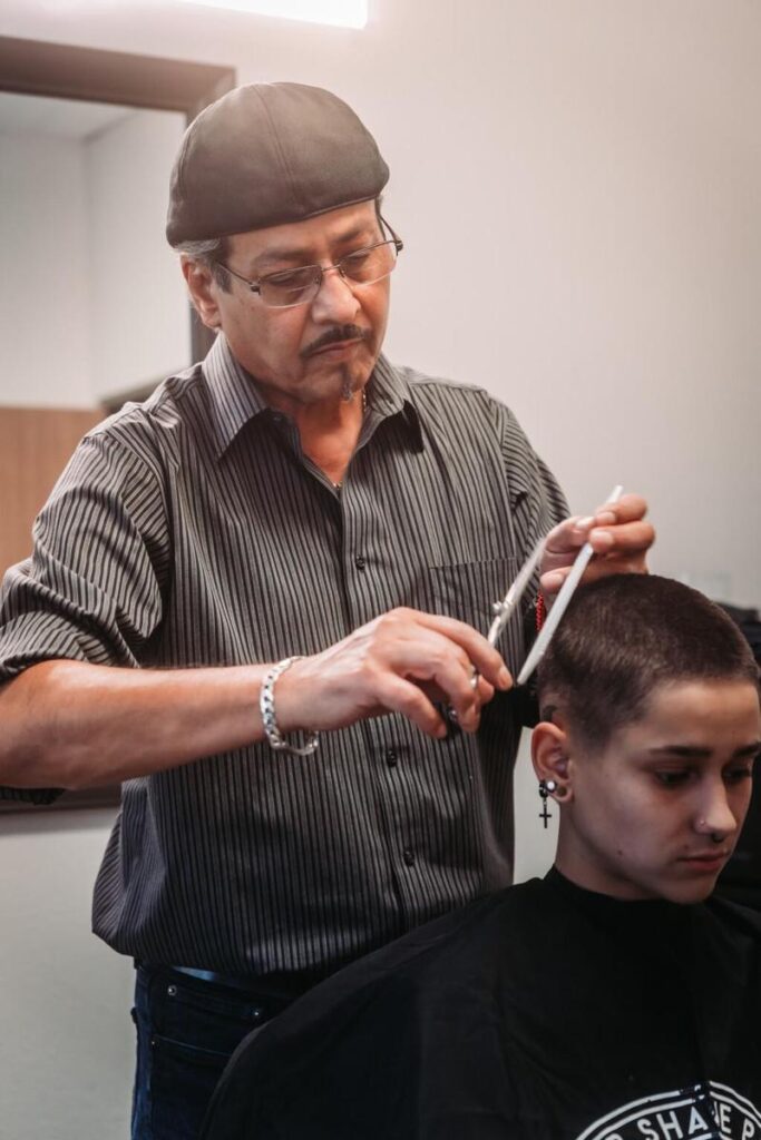 Roberto, one of the master barbers at our men's barbershop giving a haircut